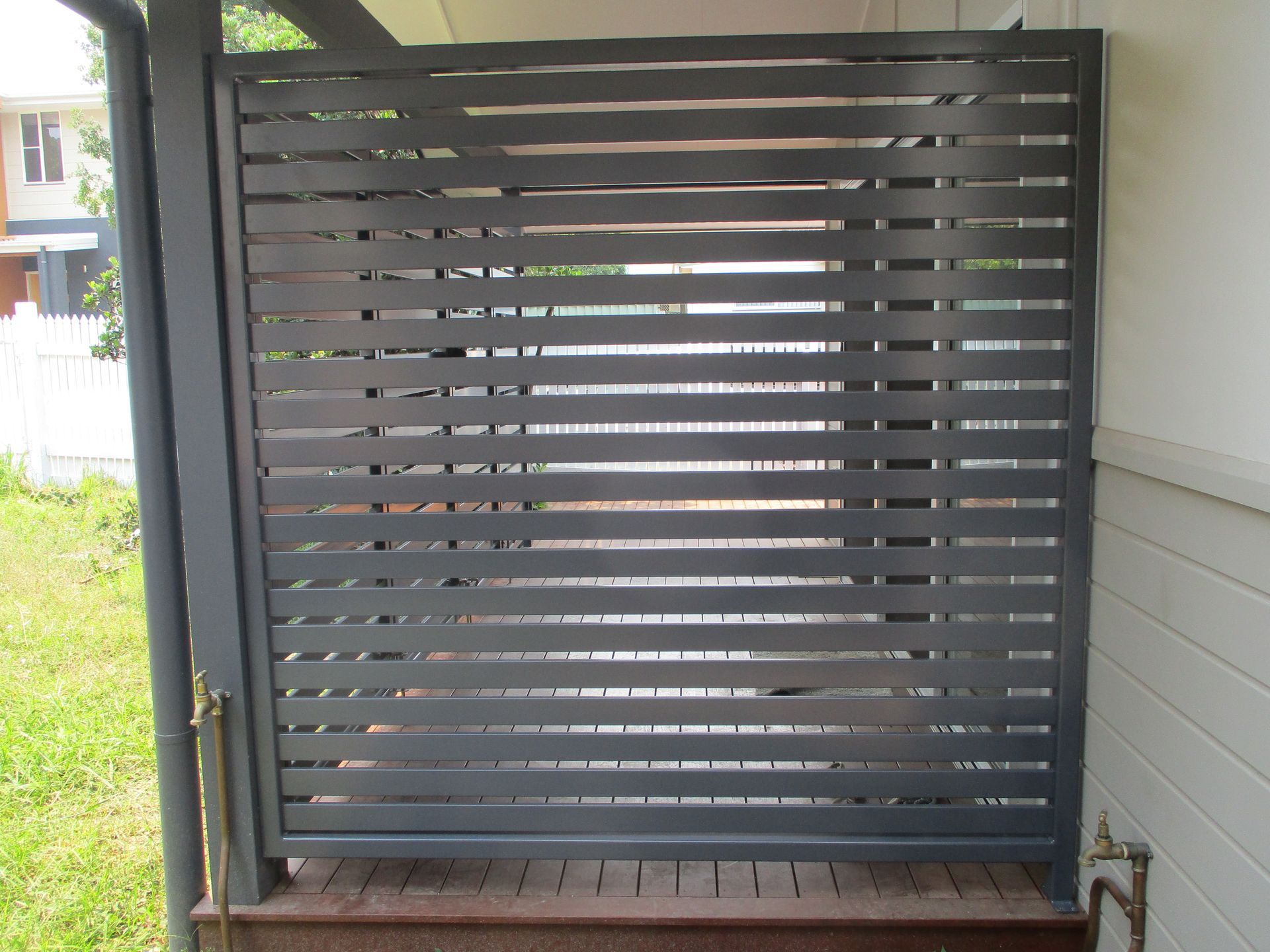 A gray fence is sitting on the side of a house — Fabricator In Coffs Harbour, NSW