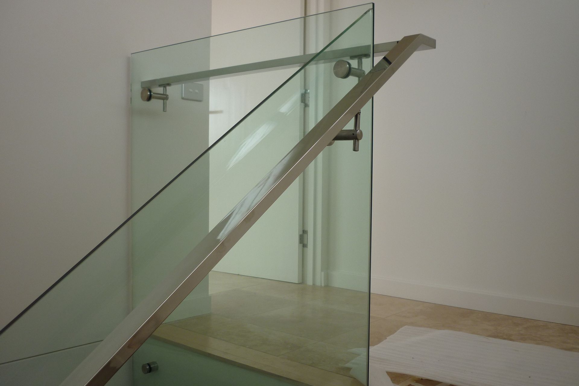 A staircase with a glass railing and a stainless steel handrail — Fabricator In Coffs Harbour, NSW