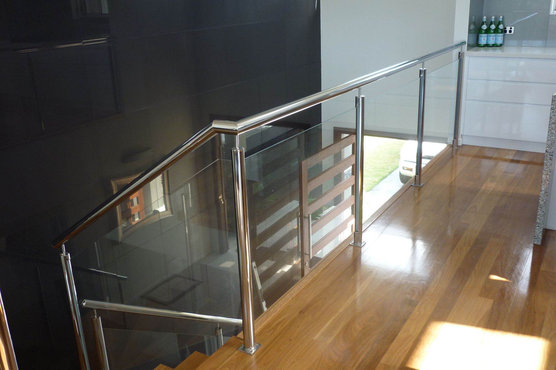 A staircase with a glass railing and a wooden floor — Fabricator In Coffs Harbour, NSW