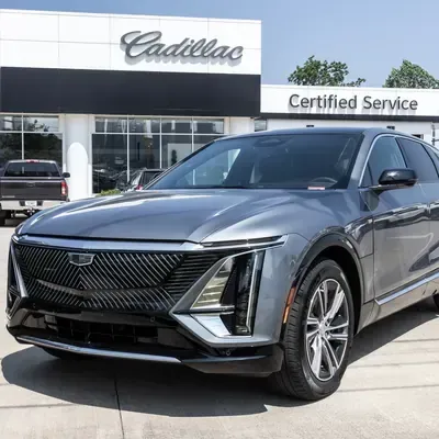 Gray Cadillac SUV parked outside a Cadillac dealership service center