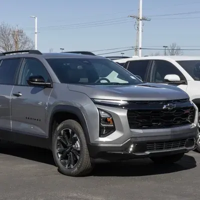 Gray SUV parked in a lot, front three-quarter view beside a white vehicle.