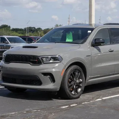 Gray Dodge SUV parked in a lot under a partly cloudy sky