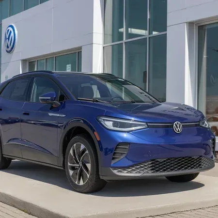 Blue Volkswagen ID.4 SUV parked outside a Volkswagen dealership