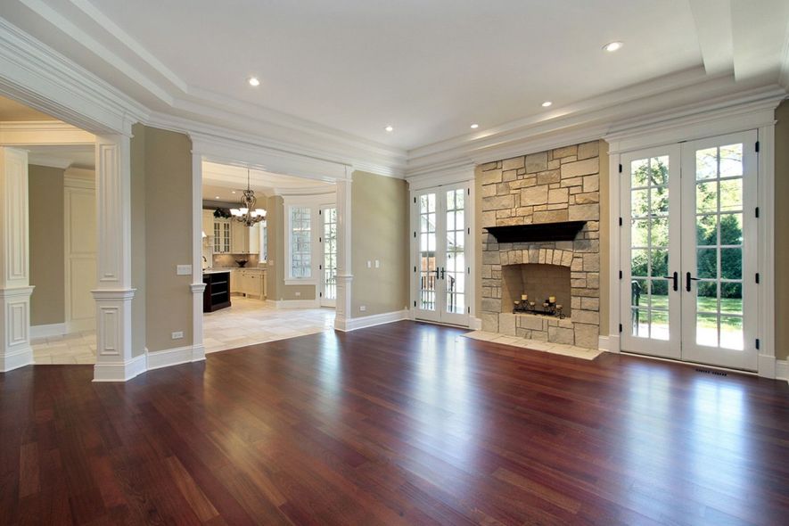 An empty living room with hardwood floors and a fireplace.