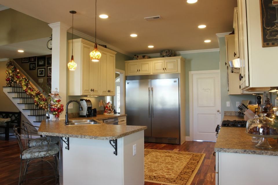 Kitchen with cream cabinets, stainless steel refrigerator, and granite countertops.