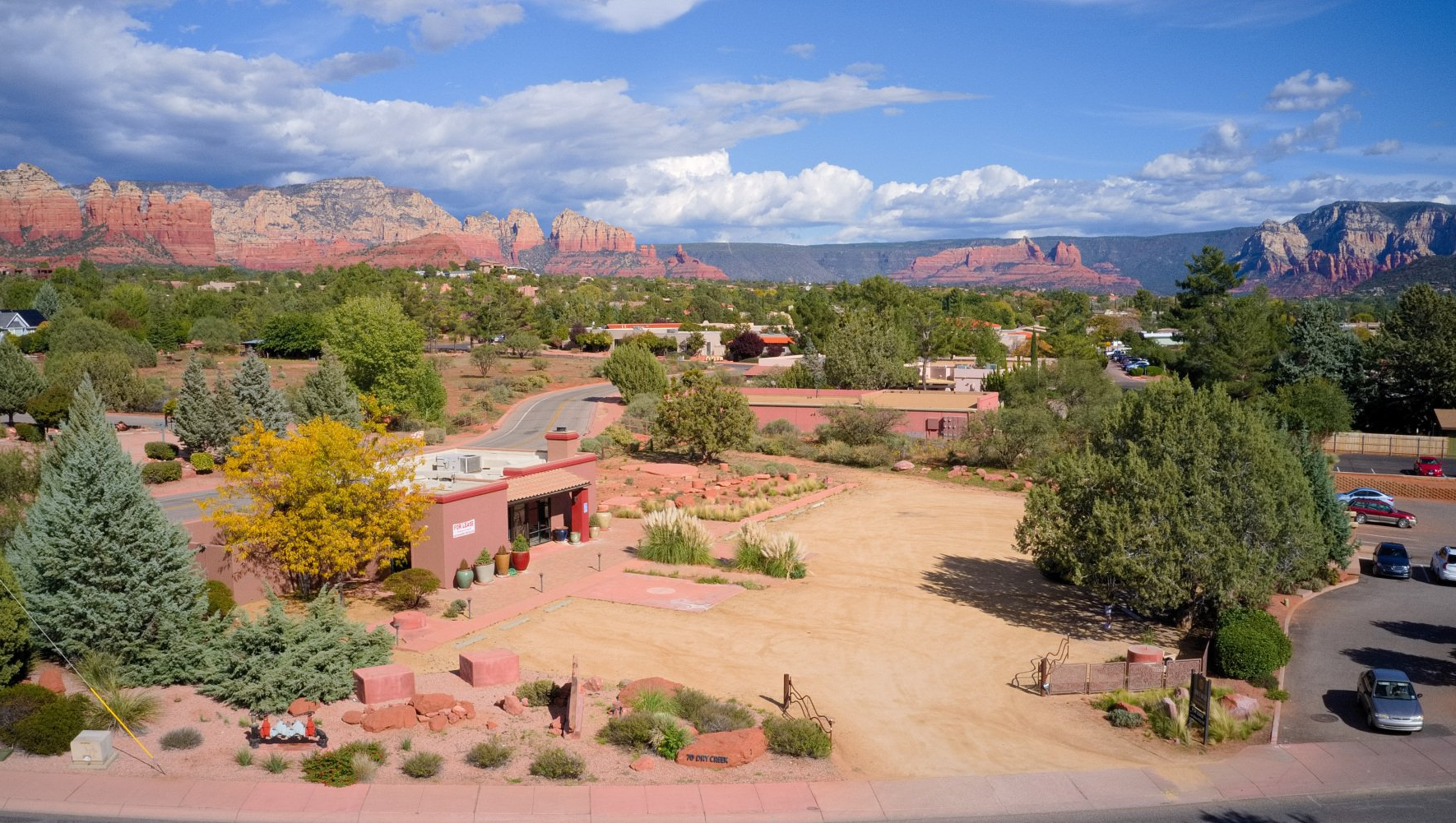 A southwestern townscape with red rock formations in the background.