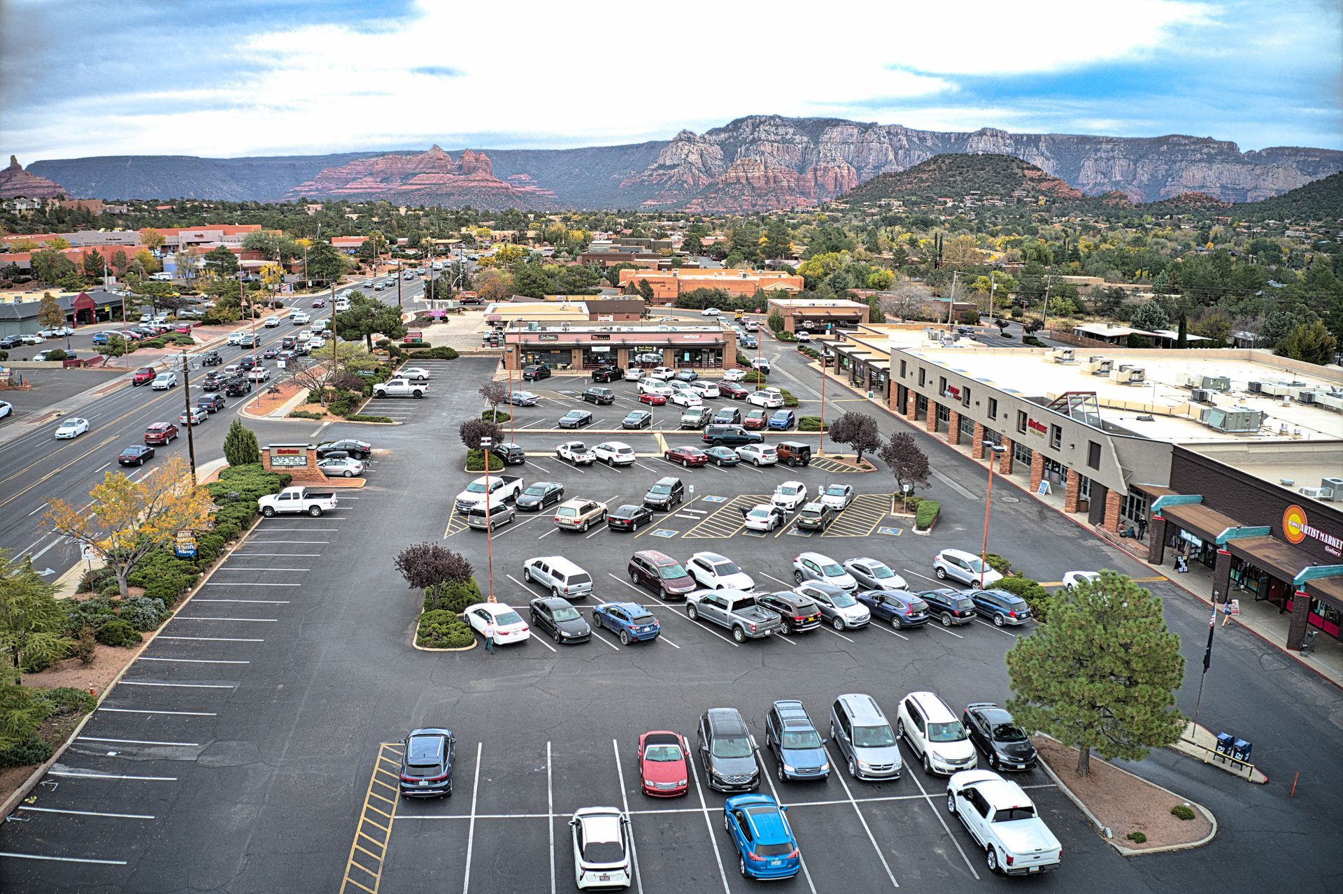 Aerial view of a parking lot in Sedona, Arizona. Cars parked with red rock mountains in the distance.