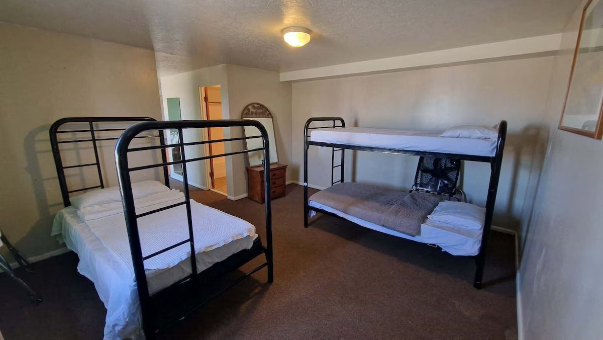 A bedroom with two bunk beds and two beds.