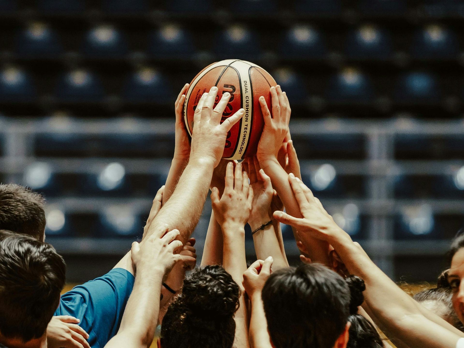 team huddle holding a ball in the center