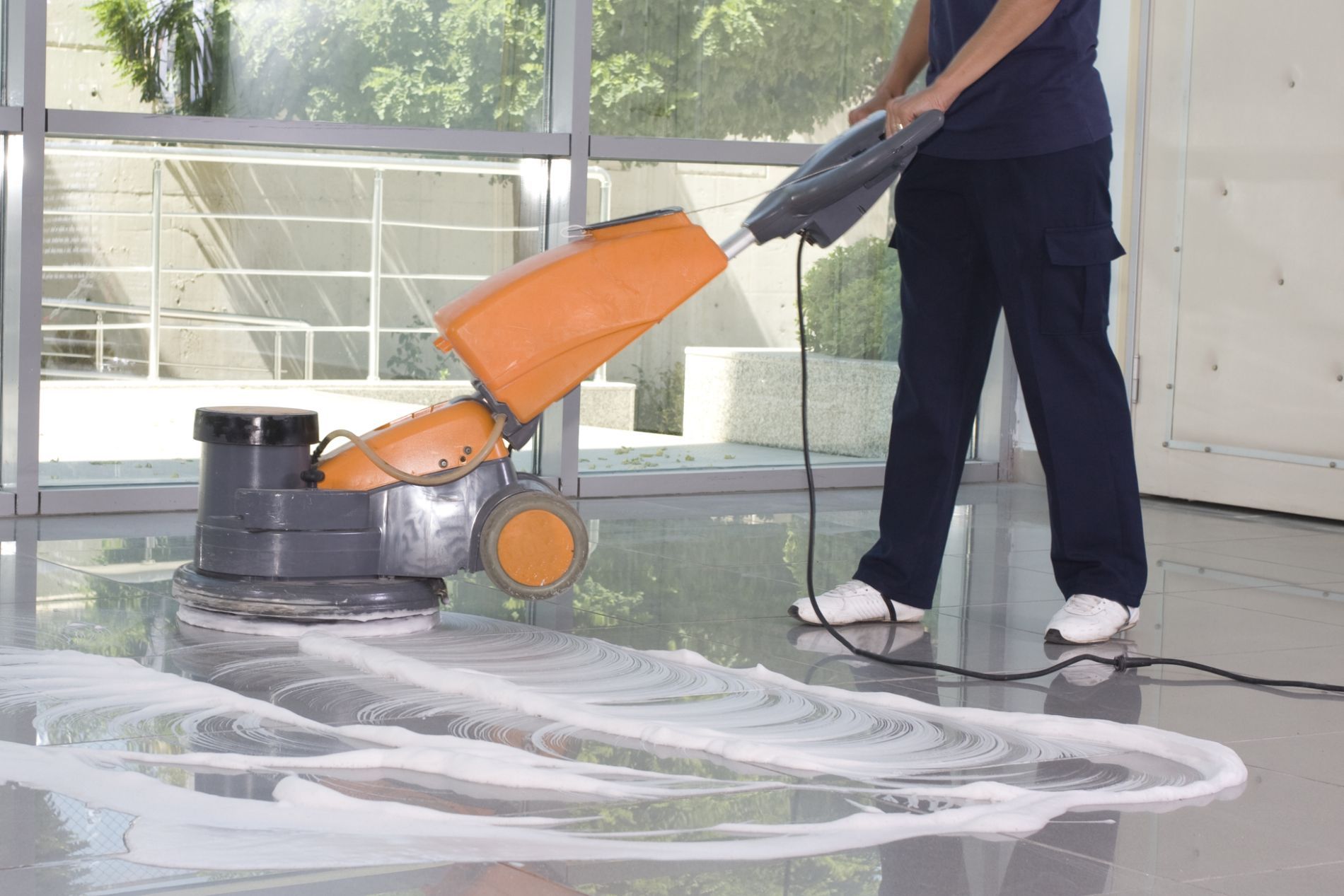 Worker waxing tiled floor