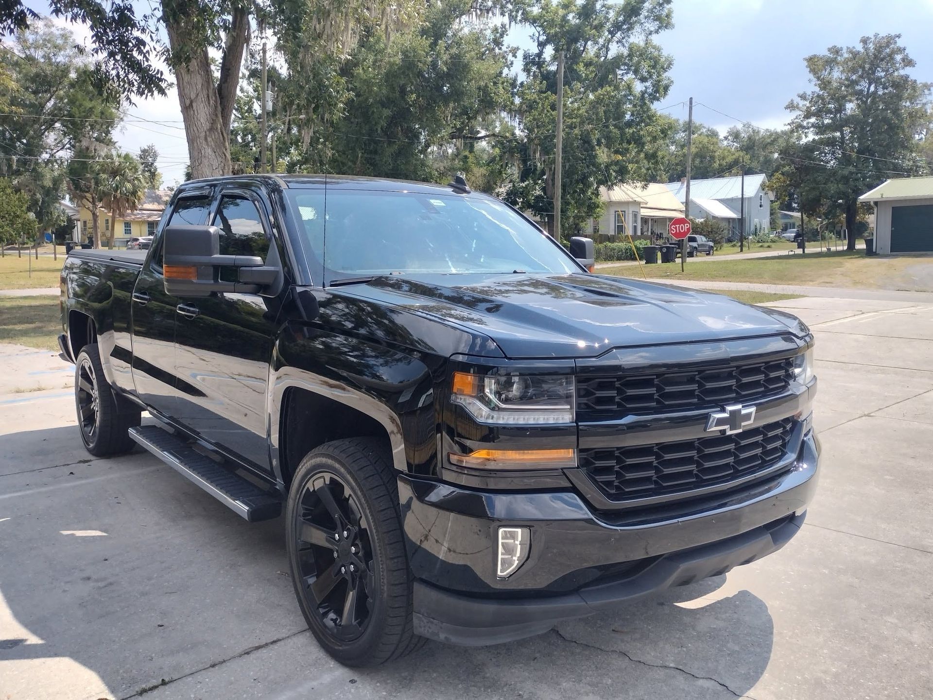 Black lifted pickup truck parked outdoors on a sunny day