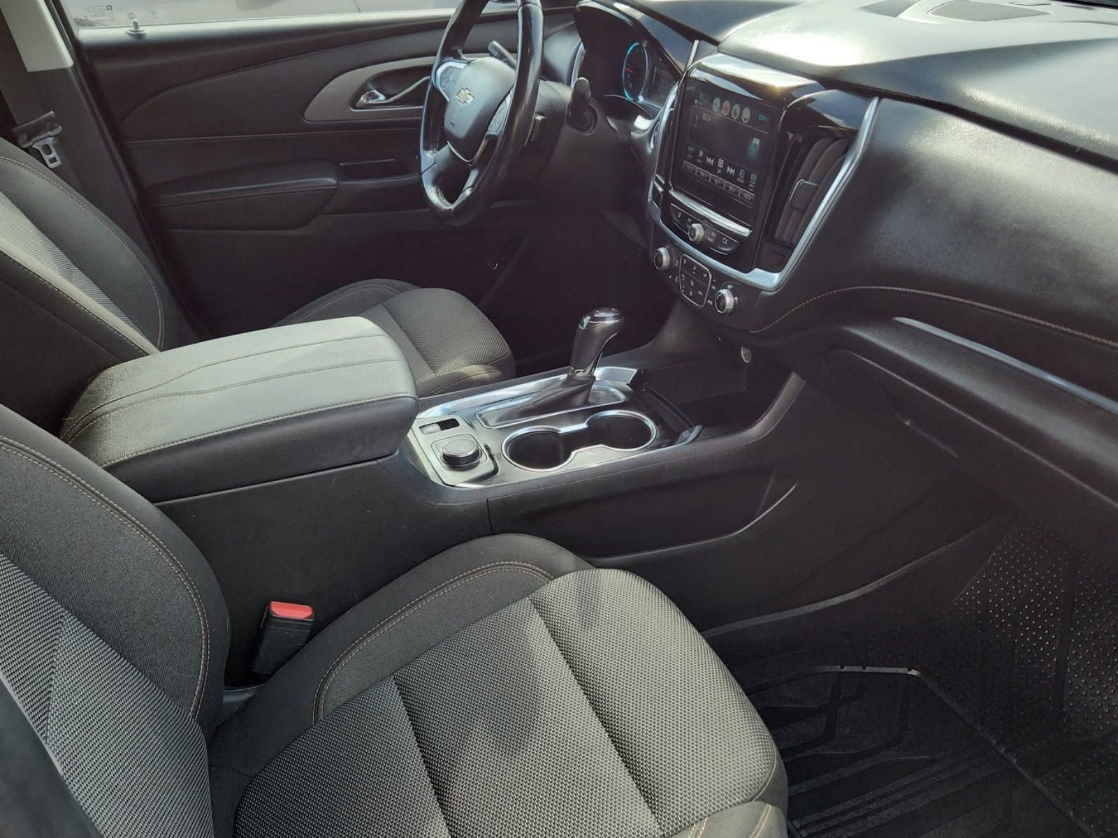 Car interior with black seats, center console, and dashboard, viewed from the passenger side