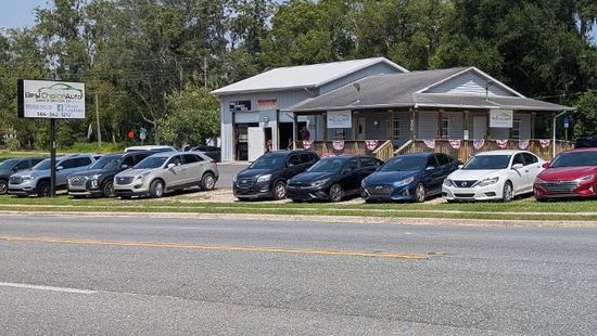 Rows of parked cars in a sunlit lot, viewed from above.