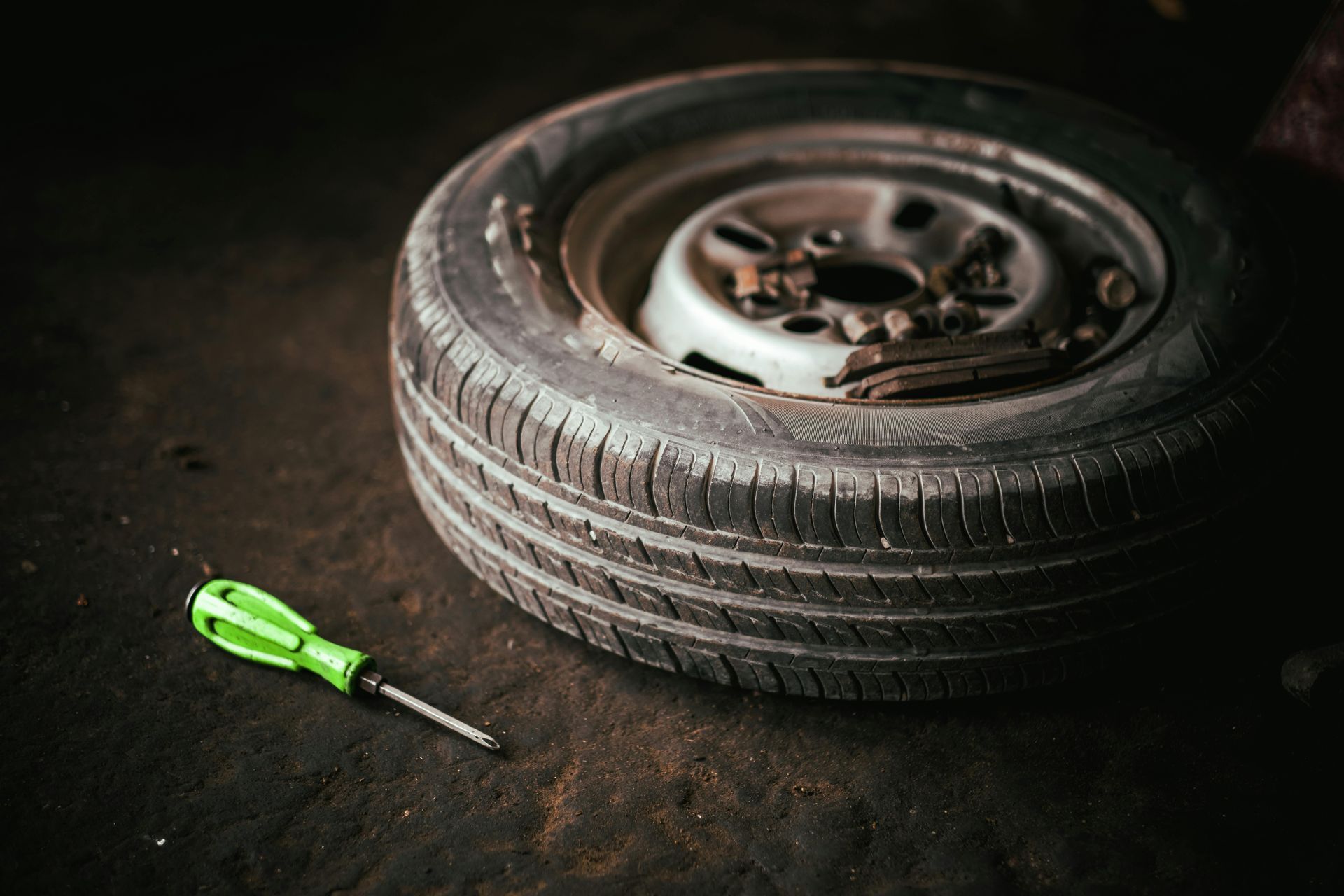 Flat Car Tire with Green Screwdriver | Urban Auto Workz
