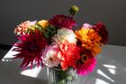 A basket filled with flowers is sitting on a wooden table.