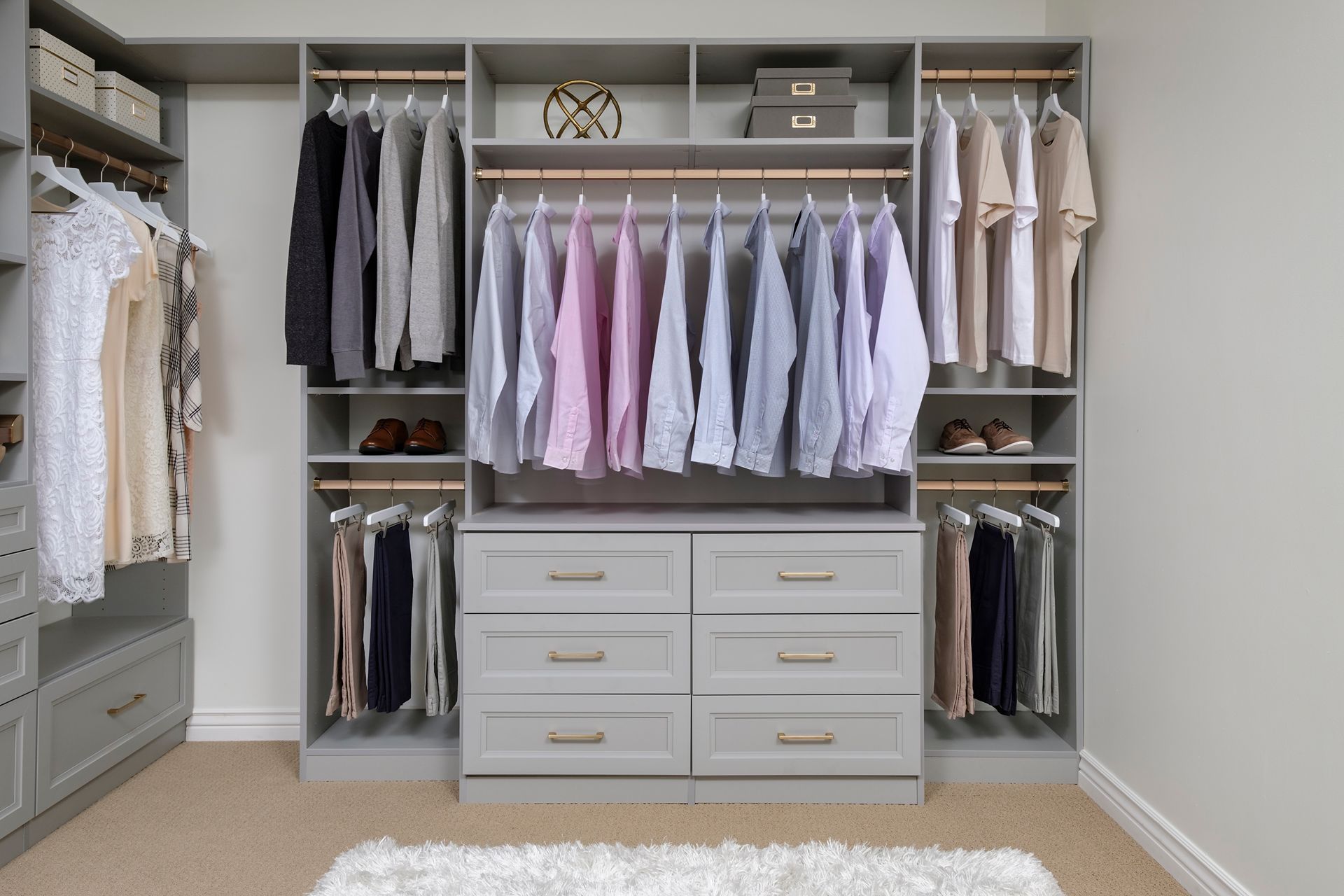 Built-in walk-in closet with hanging clothes, drawers, shelves, and a light gray finish