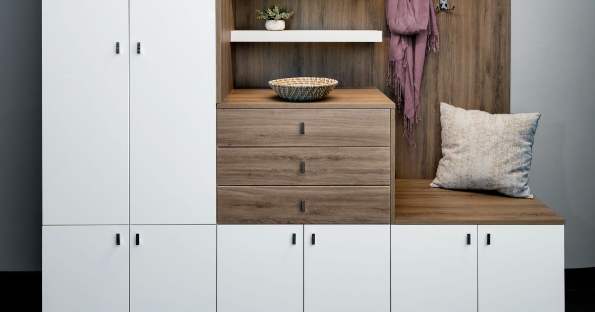 Grey walk-in closet with desk area. Includes hanging clothes, shelves, and a chair.