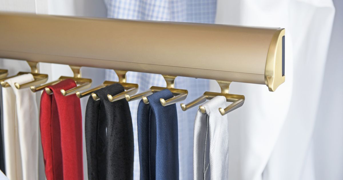 Closet rod with hanging shirts and pants in red, navy, black, and white