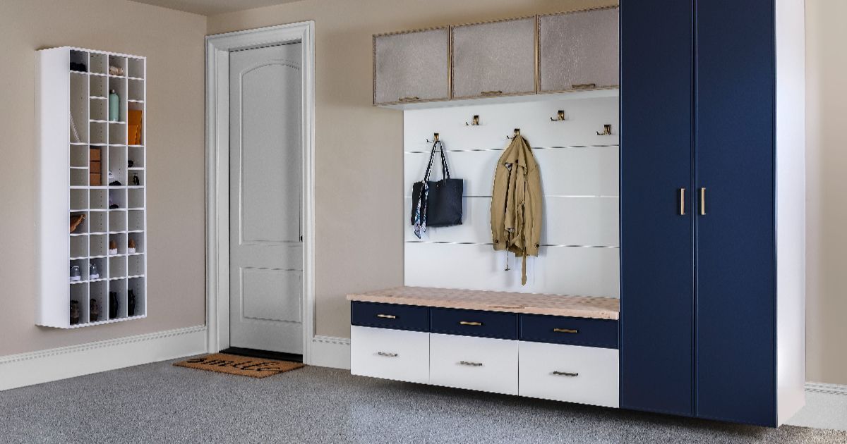 Grey walk-in closet with desk area. Includes hanging clothes, shelves, and a chair.