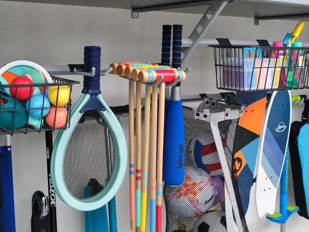 Colorful rack of tennis rackets, balls, and sports gear on a shelf