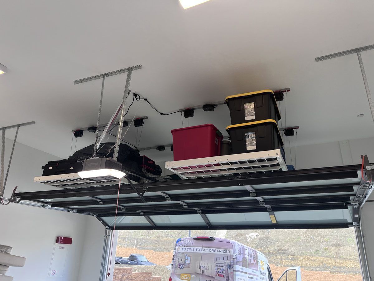 Ceiling-mounted storage rack with bags and bins in a garage-like room