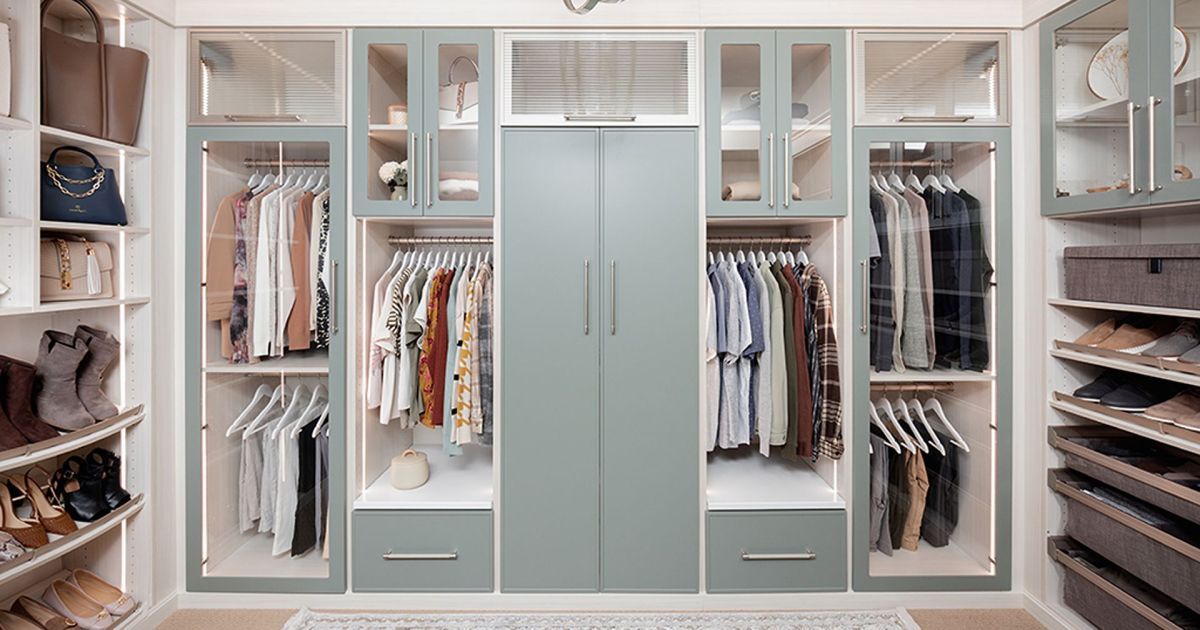 Spacious walk-in closet with hanging clothes, shelves, drawers, and centered mirrored doors