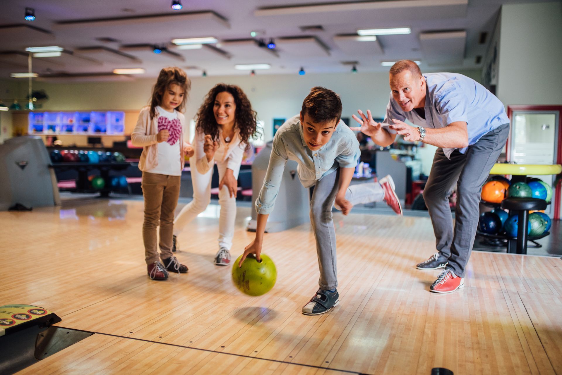 A family celebrating a bowling-themed birthday party in Madison, WI.