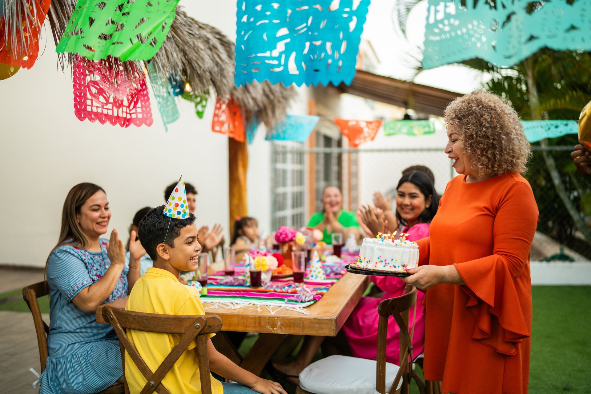 Outdoor celebration with children’s party service serving cake to smiling kids at decorated table. Outdoor celebration with children’s party service serving cake to smiling kids at decorated table.