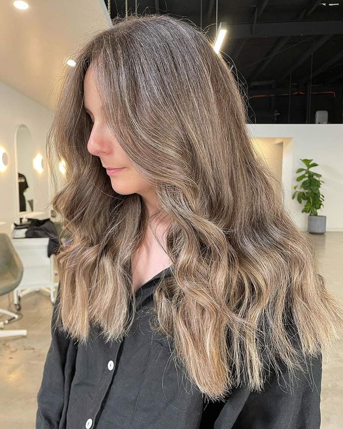 A Woman With Long Brown Hair Is Standing In A Salon Wearing A Black Shirt — Rowe Street Collective In Shepparton, VIC