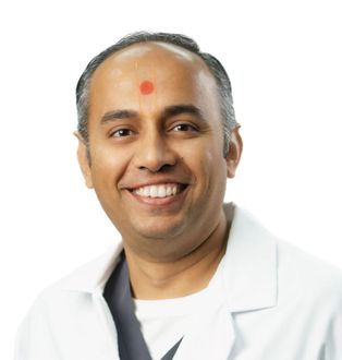 Dr Keyur Patel with a smile on his face with a red dot on his forehead.