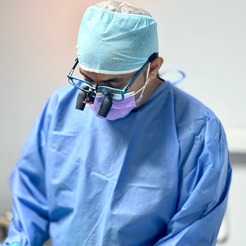 A surgeon wearing a mask and magnifying glasses