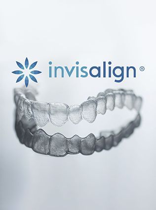 A dentist is holding a model of teeth in her hands.