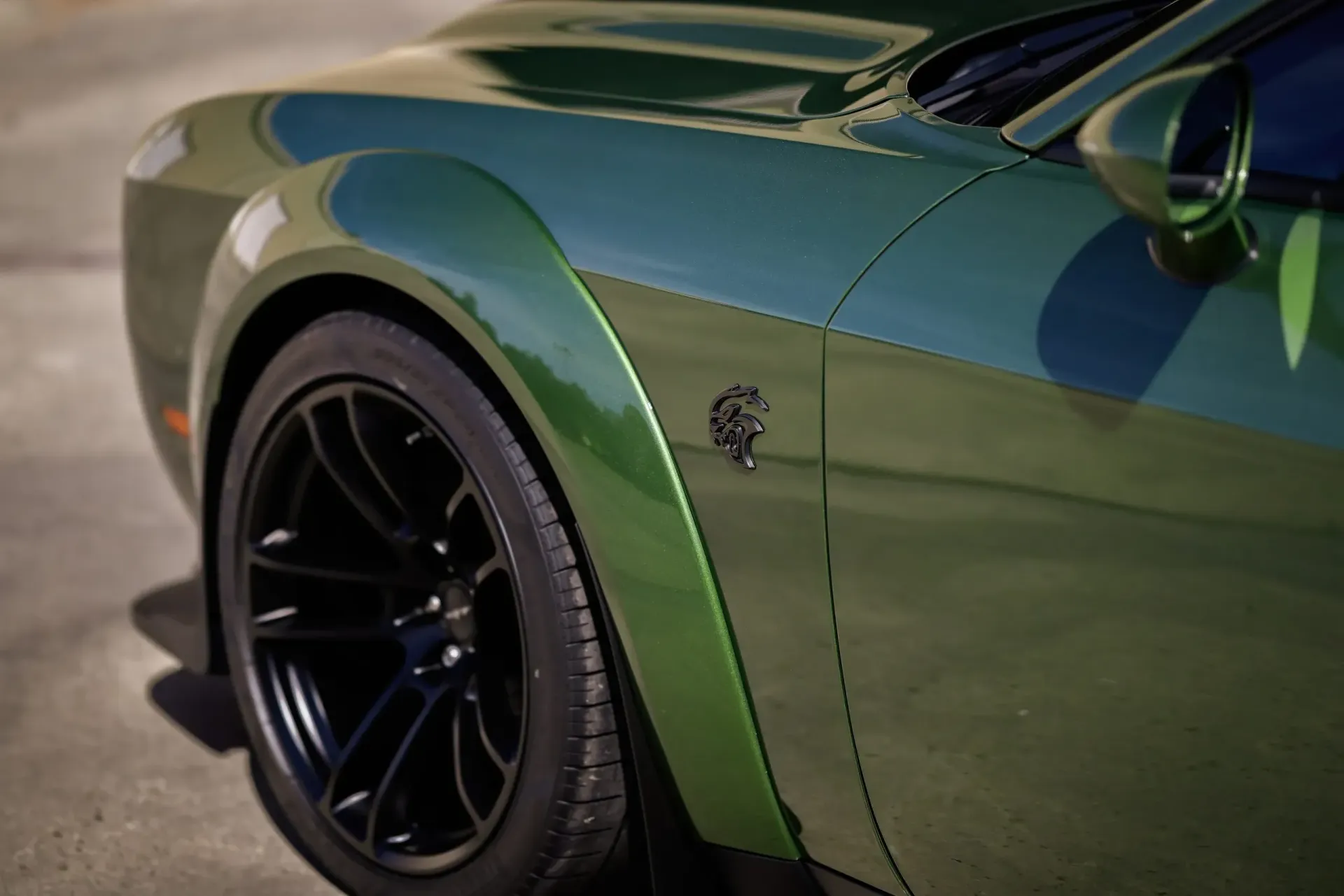 Green Dodge Challenger with black wheel and a