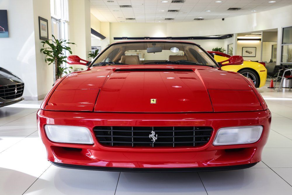Red Ferrari in a showroom, front view.