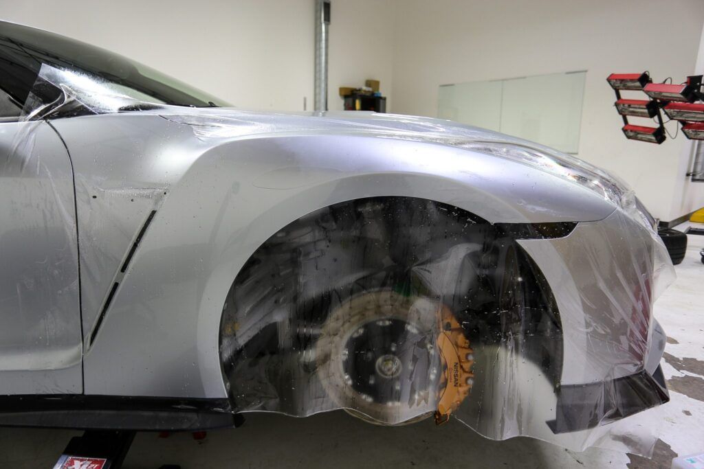 Car with clear film applied to its front quarter panel. Silver paint visible.