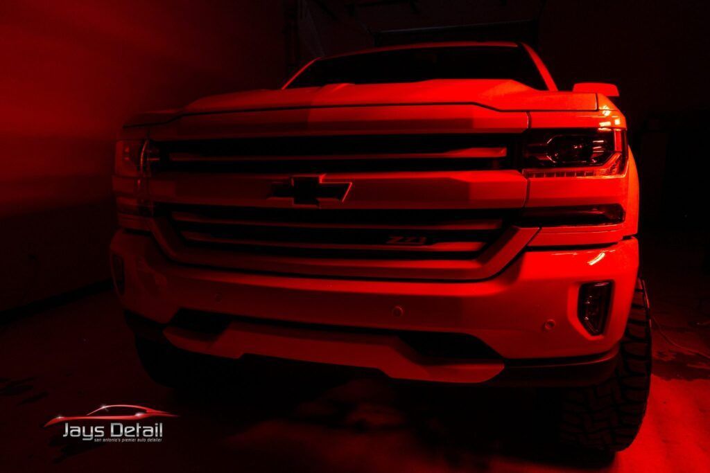 Red-lit, front view of a Chevrolet Silverado pickup truck.