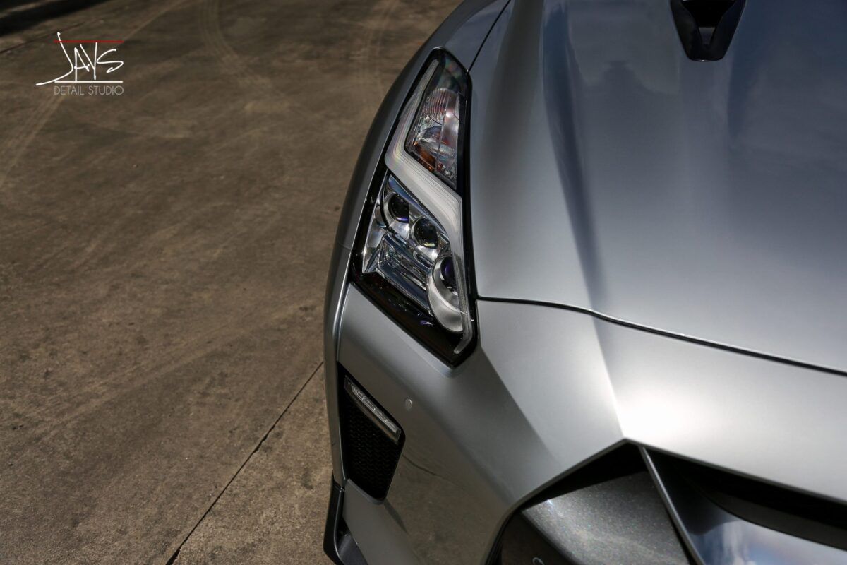 Silver sports car's front corner, headlight detail.