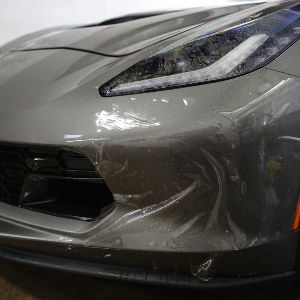 Gray sports car bumper with clear protective film.