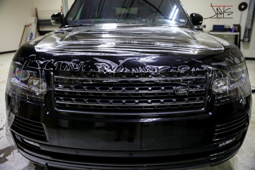 Black Range Rover with protective film applied to its front.