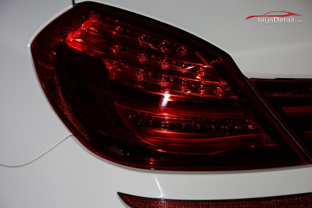 Red car tail light on a white car, close-up.