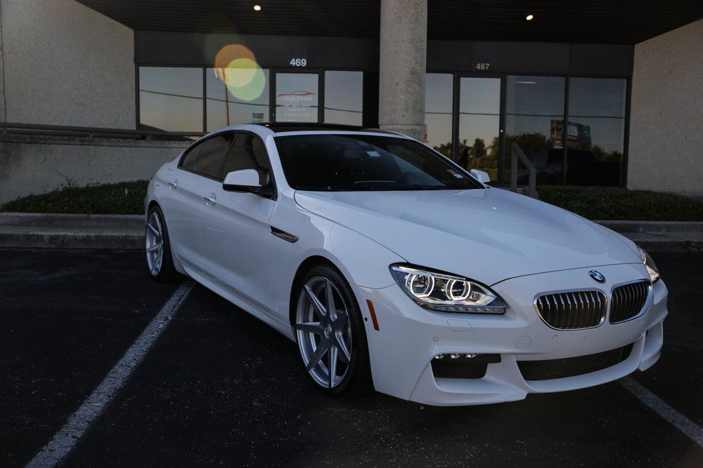 White BMW coupe parked outside a building.