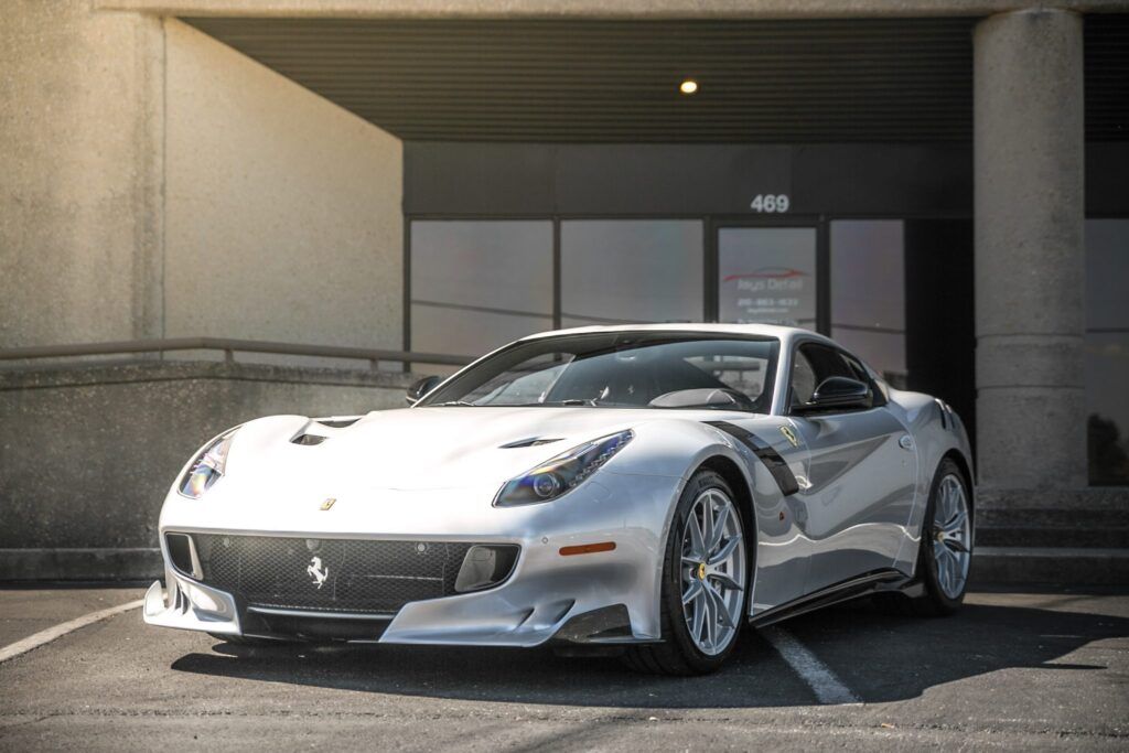 Silver Ferrari sports car parked in front of a building with the number 400.