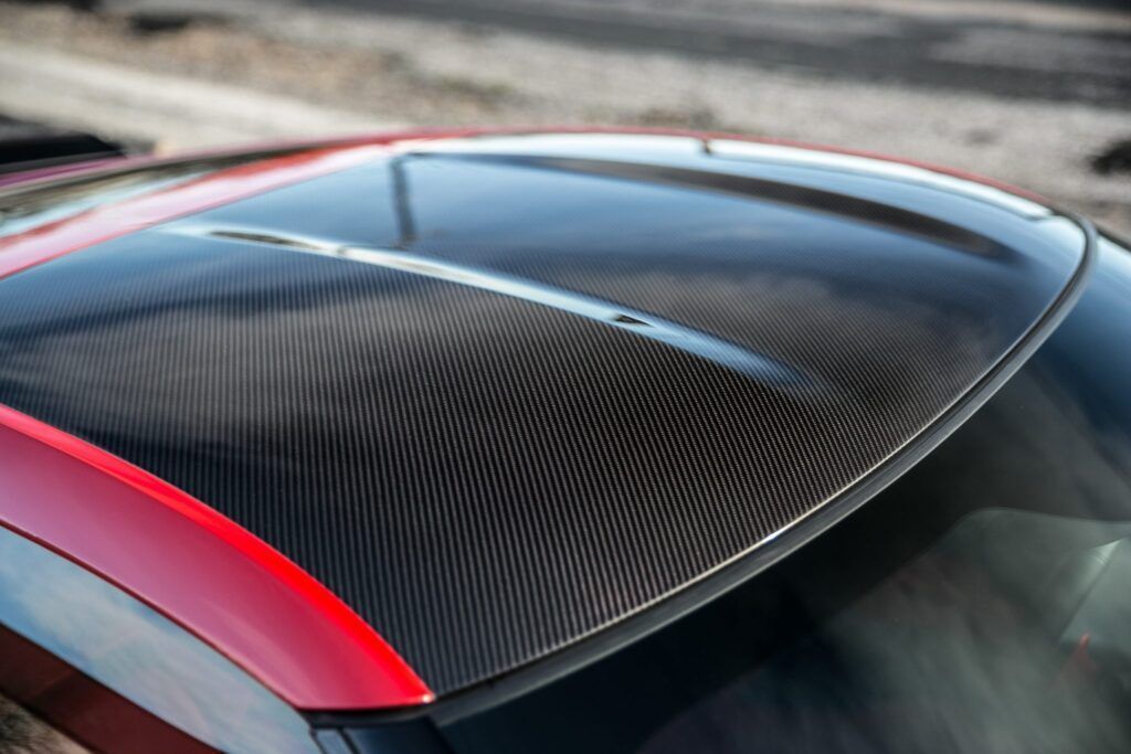 Carbon fiber car roof with red trim.