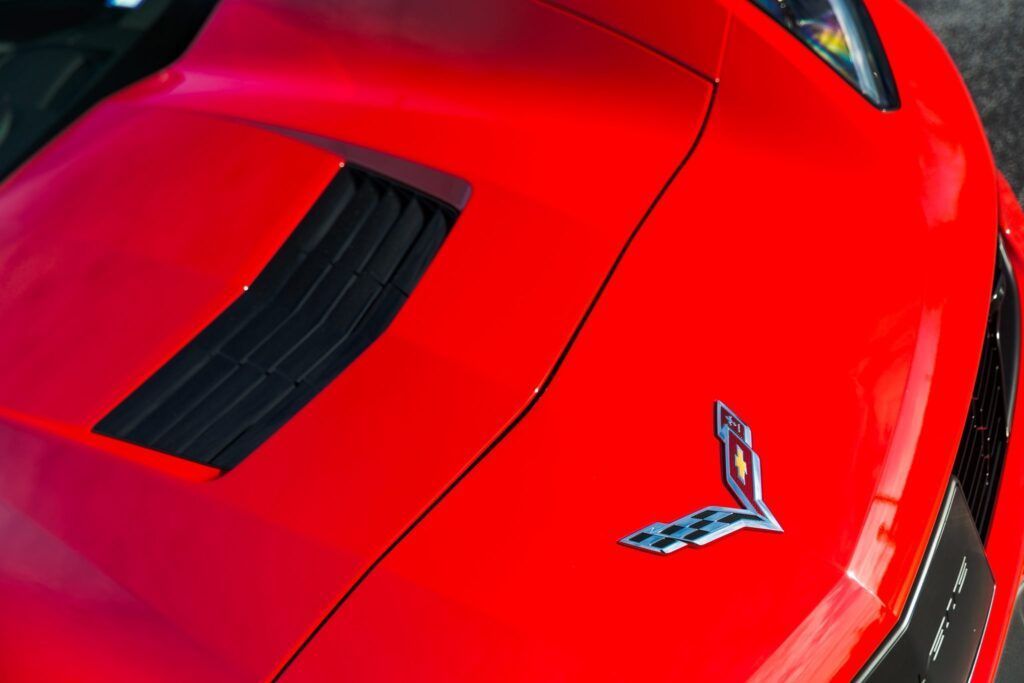 Red Corvette hood with black vent and emblem.