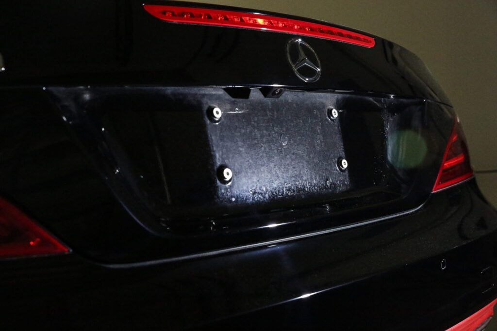 Black Mercedes-Benz rear with license plate area; red tail lights and emblem visible.