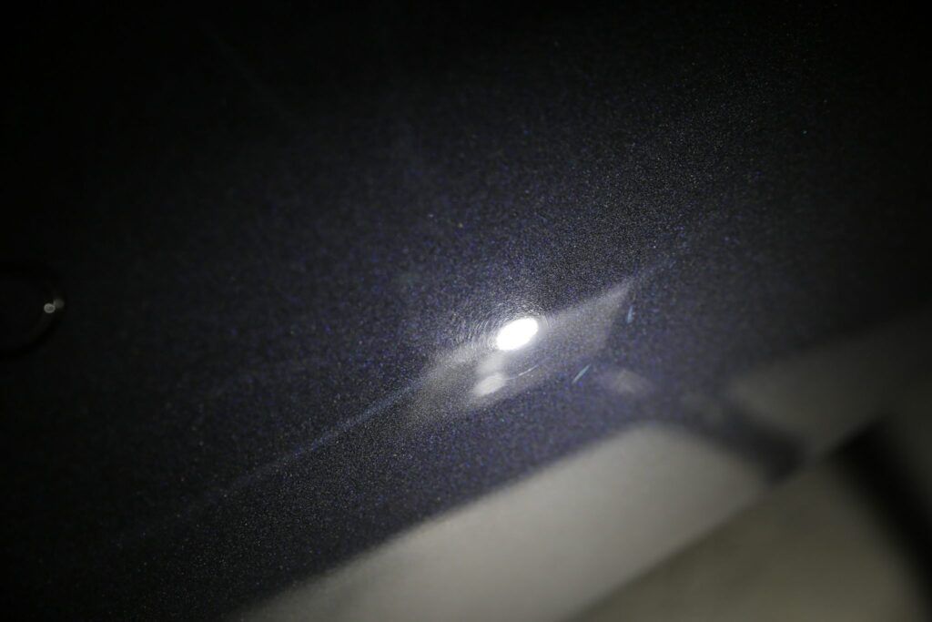 Interior car ceiling with a bright overhead light shining down on it.