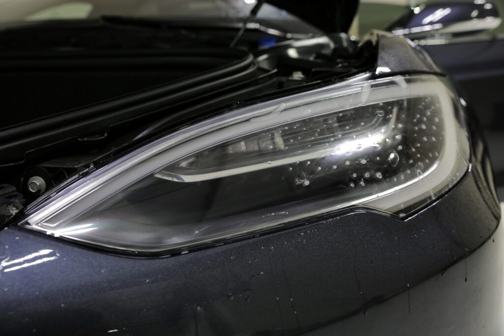 Close-up of a car's headlight, featuring a sleek, modern design.