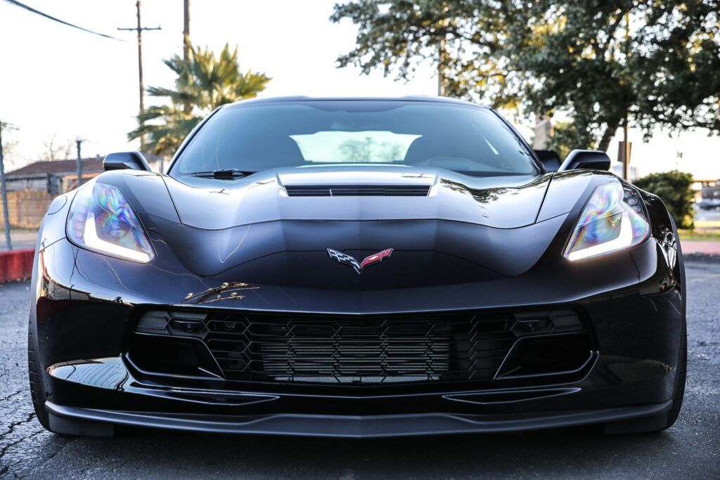 Black Corvette sports car parked, facing forward.
