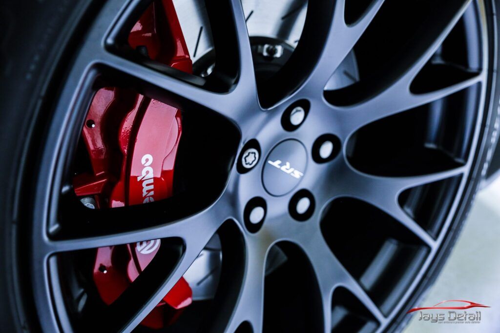 Black car wheel with red brake calipers.