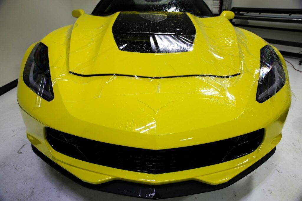 Yellow Corvette car front, wrapped in clear protective film.